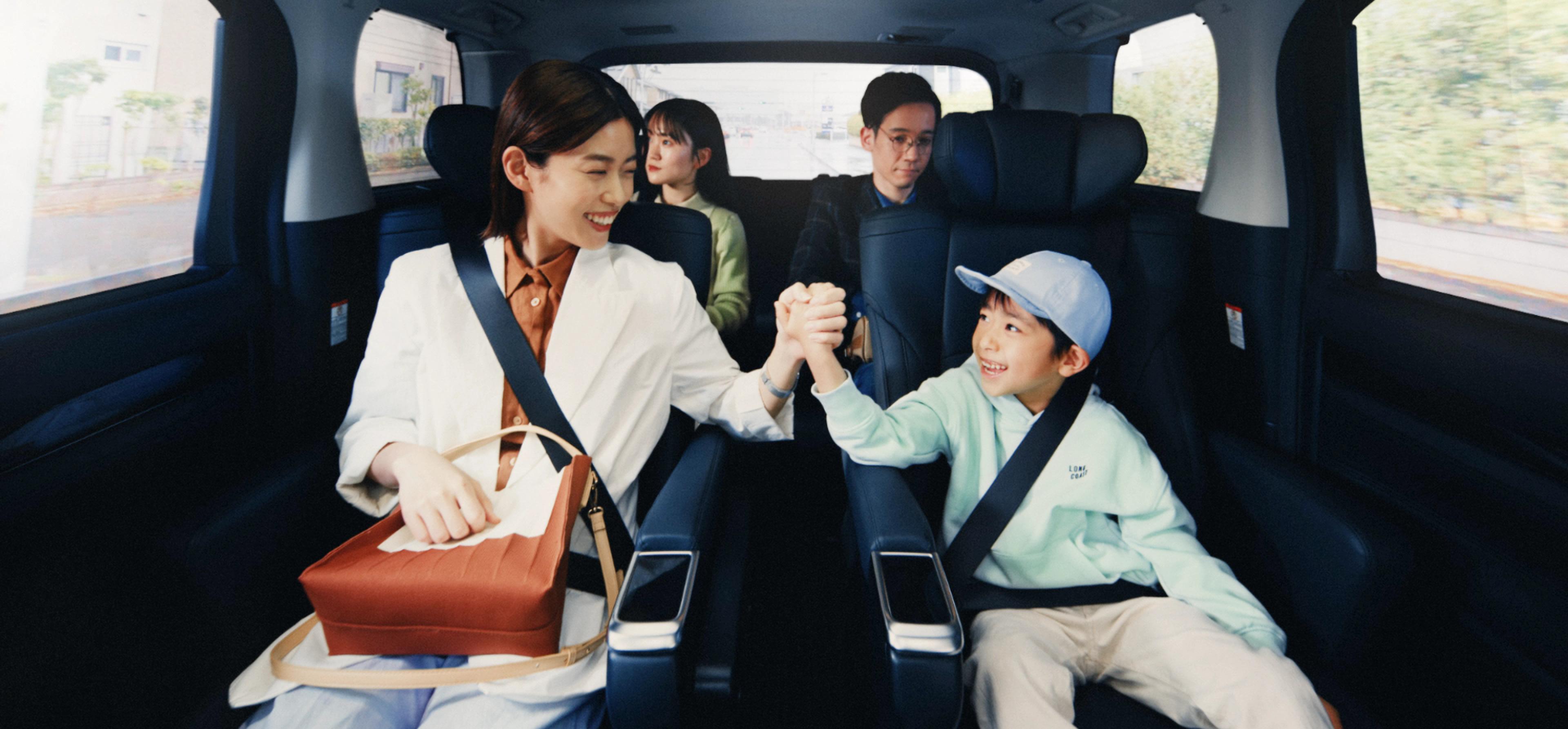A woman, a child, and two other groups are sharing the ride.